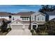 Two-story home showcasing a three-car garage, manicured landscaping, and inviting curb appeal at 5709 Camila Song Ln, Tampa, FL 33625