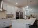 Modern kitchen with white cabinets, stainless steel appliances, and a large quartz island with seating at 5709 Camila Song Ln, Tampa, FL 33625