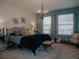 Serene main bedroom with a plush bed, decorative chandelier, and plenty of natural light at 5709 Camila Song Ln, Tampa, FL 33625
