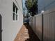 Narrow side yard with a gray privacy fence, stone path, and low-maintenance landscaping for a clean look at 5709 Camila Song Ln, Tampa, FL 33625