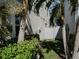 Side yard with lush greenery, palm trees, and a white fence, creating a private outdoor space at 5709 Camila Song Ln, Tampa, FL 33625