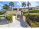 Exterior showing the building and lush landscaping with a walkway and stairs at 7520 Sunshine Skyway S Ln # T18, St Petersburg, FL 33711