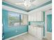 Functional kitchenette with ample white cabinetry and a window providing natural light at 7520 Sunshine Skyway S Ln # T18, St Petersburg, FL 33711