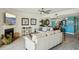 Comfortable living room with fireplace, white couches, and view to the kitchen at 7520 Sunshine Skyway S Ln # T18, St Petersburg, FL 33711