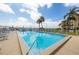 Inviting community swimming pool with lounge chairs and palm trees against a water view backdrop at 7520 Sunshine Skyway S Ln # T18, St Petersburg, FL 33711