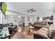 Spacious living room with hardwood floors, ceiling fan, and an open floor plan leading into the kitchen and stairway at 10409 Waterstone Dr, Riverview, FL 33578