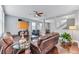 Comfortable living room with two leather sofas, glass tables, wood floors, and open access to other rooms at 10409 Waterstone Dr, Riverview, FL 33578