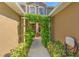 View of an arched, greenery-covered entrance leading into the home's front door at 18827 Duquesne Dr, Tampa, FL 33647