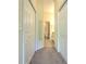 Hallway with carpet runner leading to a bathroom with closet doors on each side at 18827 Duquesne Dr, Tampa, FL 33647