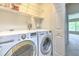 Laundry room with newer front load washer and dryer, with a door open to a living area at 18827 Duquesne Dr, Tampa, FL 33647