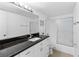 Bright bathroom featuring a long vanity with a dark countertop and a shower with glass doors at 2617 Cove Cay Dr # 604, Clearwater, FL 33760