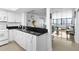 Bright kitchen featuring white cabinets, black countertops, and an open design to the living area with beautiful water views at 2617 Cove Cay Dr # 604, Clearwater, FL 33760