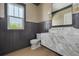 This powder room is highlighted by black wainscotting and a unique marble countertop at 323 Appian Ne Way, St Petersburg, FL 33704