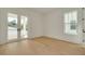 Bright bedroom with natural light and patio access showcases wood flooring and minimalist trim at 323 Appian Ne Way, St Petersburg, FL 33704