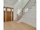 Bright entryway features a striking staircase, elegant wood floors, and classic white paneled walls at 323 Appian Ne Way, St Petersburg, FL 33704