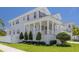 A luxurious two-story home boasts a wide porch with elegant columns, fresh landscaping, and a well-maintained lawn at 323 Appian Ne Way, St Petersburg, FL 33704