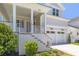 Inviting front entrance with landscaped steps leading to a covered porch and a glimpse of the two-car garage at 323 Appian Ne Way, St Petersburg, FL 33704