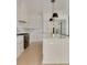 Open kitchen boasts sleek white cabinets, marble countertops, a large island, and high-end appliances at 323 Appian Ne Way, St Petersburg, FL 33704