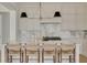 Gourmet kitchen island with marble countertops and seating for four complements designer light fixtures at 323 Appian Ne Way, St Petersburg, FL 33704