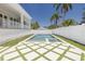 A rectangular pool and spa are bordered by a white fence with modern geometric tile and artificial turf accents at 323 Appian Ne Way, St Petersburg, FL 33704