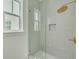 Modern tiled shower with glass door, built-in niche, and gold fixtures showcases contemporary design at 323 Appian Ne Way, St Petersburg, FL 33704