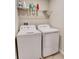 Laundry room with white washer and dryer set, plus shelving for storage at 3818 Cat Mint St, Tampa, FL 33619