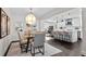 Open-concept dining area with modern lighting, glass-top table, and seamless flow to the kitchen at 7218 Park S St, St Petersburg, FL 33707