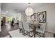 Bright dining room with a modern chandelier, glass table, seating for four and eye-catching abstract art at 7218 Park S St, St Petersburg, FL 33707