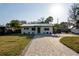 Charming exterior with a metal roof, freshly painted facade, neat landscaping, and a paved driveway at 7218 Park S St, St Petersburg, FL 33707