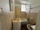 A basic bathroom features a tiled shower-tub, sink, and standard fixtures at 8302 N Lois Ave, Tampa, FL 33614