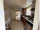 Kitchen featuring essential appliances, wood cabinets, and a window, ready for renovation at 8302 N Lois Ave, Tampa, FL 33614