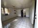 An open living room featuring tile floors, a window air conditioner, and a bathroom entrance at 8302 N Lois Ave, Tampa, FL 33614