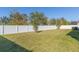 A full view of the fenced backyard and green lawn with blue skies on a sunny day at 12312 Bay Estuary Bnd, Riverview, FL 33579