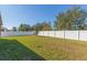 Picture of the fenced backyard and large green lawn on a sunny day with blue skies and a few trees at 12312 Bay Estuary Bnd, Riverview, FL 33579