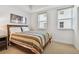 A bright bedroom with a bed, artwork, neutral carpet, and blinds, offering a comfortable and inviting space at 17717 Gulf Blvd # 601, Redington Shores, FL 33708