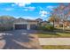 Charming home featuring a three-car garage and a brick driveway at 2564 Grand Cypress Blvd, Palm Harbor, FL 34684