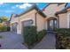 Charming home featuring a two-car garage and a beautifully landscaped walkway leading to the front door at 2564 Grand Cypress Blvd, Palm Harbor, FL 34684