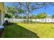 Expansive backyard featuring a mature tree, manicured lawn, and white privacy fence at 3218 21St N St, St Petersburg, FL 33713