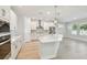 Bright kitchen with quartz counters, a large island, stainless steel appliances, and pendant lighting open to the living room at 3218 21St N St, St Petersburg, FL 33713