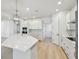 Bright and airy kitchen with a large island, modern lighting, stainless steel appliances, and a light wood floor at 3218 21St N St, St Petersburg, FL 33713