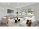 Sun-filled living room with large windows, stylish furniture, and modern entertainment center at 3218 21St N St, St Petersburg, FL 33713