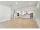 Open-concept living space with white walls and light hardwood floors that connects the living room, dining room, and kitchen at 3218 21St N St, St Petersburg, FL 33713