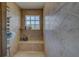 Walk-in shower featuring a bench, tile surround, a window, and various shower accessories at 783 Placido Ne Way, St Petersburg, FL 33704