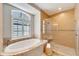 Luxurious bathroom featuring a soaking tub and a separate glass-enclosed shower at 1024 Sonata Ln, Apollo Beach, FL 33572