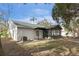 Backyard with grassy area, trees, screened porch and house at 1628 Baker Rd, Lutz, FL 33559