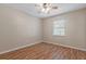 Cozy bedroom featuring wood laminate flooring, a ceiling fan, and a window with natural light at 1628 Baker Rd, Lutz, FL 33559