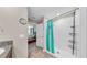 Clean bathroom showcasing a tiled shower with a blue curtain at 17102 Yellow Pine St, Wimauma, FL 33598