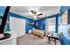Bright bedroom featuring a ceiling fan, window, and a decorative blue accent wall at 17102 Yellow Pine St, Wimauma, FL 33598