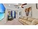 Comfortable living room featuring a plush sofa, accent chair, ceiling fan, and a large elephant art piece at 17102 Yellow Pine St, Wimauma, FL 33598