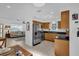 Open-concept kitchen with stainless steel appliances and wood cabinets next to the living room at 1742 Mississippi Ne Ave, St Petersburg, FL 33703